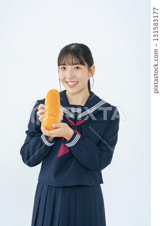一名身穿水手服、手拿髮髻的女學生 一名身穿水手服、手拿髮髻的女學生 131583177