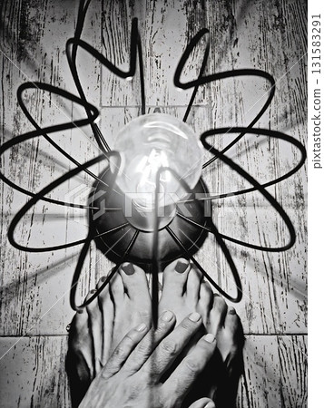 Bare feet and hand under bright artistic light bulb. 131583291