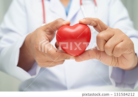 Asian woman doctor holding red heart for health in hospital. 131584212