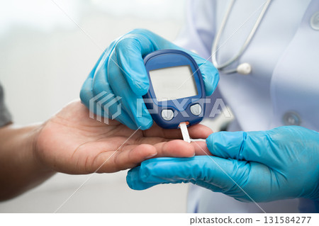 Doctor check diabetes from finger blood sugar level with digital glucose monitor measure and test stripe. 131584277