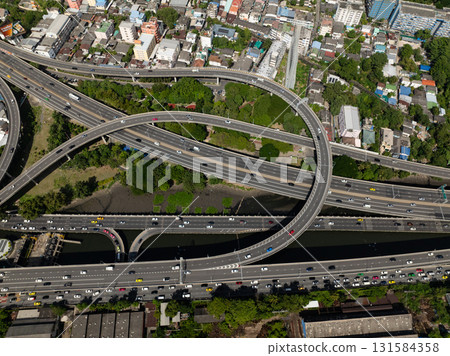 Aerial view of a complex highway network running through dense neighborhoods with some greenery. Bangkok, Thailand. Aerial view of a complex highway network running through dense neighborhoods with some greenery. Bangkok, Thailand. 131584358