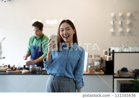 Sustainable Coffee and Community. A woman celebrating sustainability with a coffee in a vibrant cafe setting, showcasing eco-friendly choices. Sustainable Coffee and Community. A woman celebrating sustainability with a coffee in a vibrant cafe setting, showcasing eco-friendly choices. 131585636