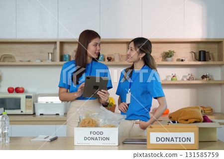 Food Donation Process. Volunteers discussing food items for community outreach. 131585759