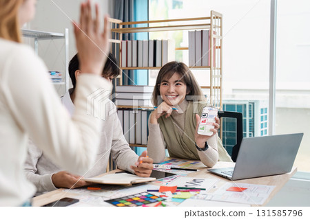 Design Presentation and Team Dynamics. A smiling designer showcases her work during a UX UI brainstorming session. 131585796