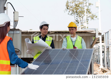Collaborative planning for solar technology. Engineers surveying solar panels and discussing installation processes. Collaborative planning for solar technology. Engineers surveying solar panels and discussing installation processes. 131585939