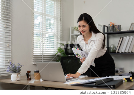 Work efficiency. Young professional managing documents on a laptop in an office. Work efficiency. Young professional managing documents on a laptop in an office. 131585964