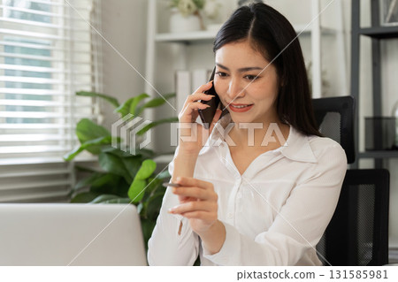 Engaging in financial discussions. A professional woman conversing on the phone while managing investment data. Engaging in financial discussions. A professional woman conversing on the phone while managing investment data. 131585981