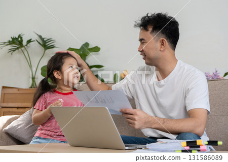 Father working from home while engaging with his daughter, showcasing family bonding and productivity. Father working from home while engaging with his daughter, showcasing family bonding and productivity. 131586089