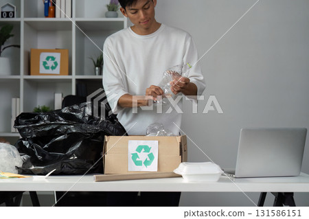 Person preparing recyclable plastic for proper disposal and recycling. Person preparing recyclable plastic for proper disposal and recycling. 131586151