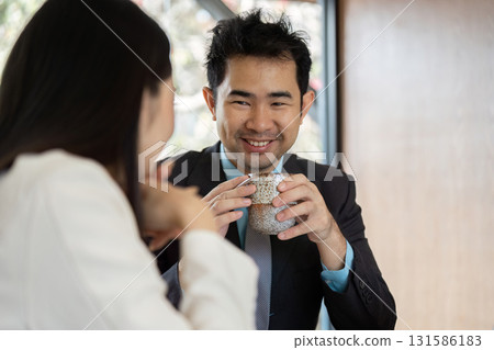 Business professionals enjoying coffee during a meeting, fostering a relaxed atmosphere. Business professionals enjoying coffee during a meeting, fostering a relaxed atmosphere. 131586183