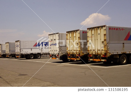 Yokosuka, Kanagawa Prefecture, Japan, August 20, 2023: Large trailers waiting in the vast parking lot of the ferry terminal 131586195