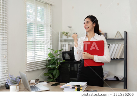 Happy accountant celebrating success in a modern office environment. 131586206