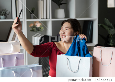 Joyful woman celebrating her online shopping haul with credit card and smartphone in a modern office. Joyful woman celebrating her online shopping haul with credit card and smartphone in a modern office. 131586344