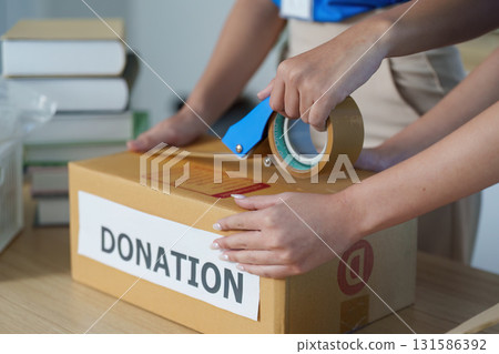 Sealing Donation Boxes. Volunteers preparing food donations for distribution. 131586392