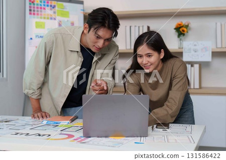 Creative UX UI Teamwork. Designers analyzing app designs on a laptop. 131586422