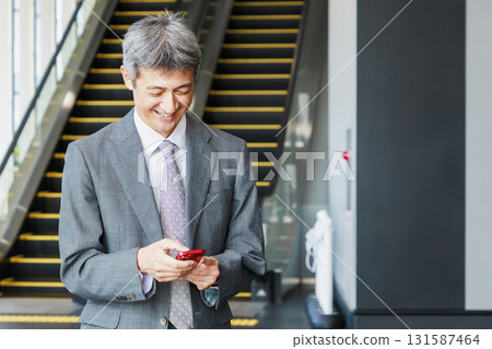A businessman operating a smartphone A businessman operating a smartphone 131587464