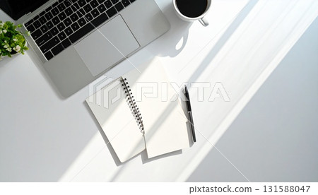 白色書桌上放著筆記型電腦和筆記本,還有咖啡杯 白色書桌上放著筆記型電腦和筆記本,還有咖啡杯 131588047