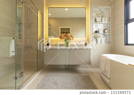 Contemporary master bathroom features a dark vanity cabinet fitted with rectangular his and hers sink and modern wall mount faucets also modern tub by the window. Contemporary master bathroom features a dark vanity cabinet fitted with rectangular his and hers sink and modern wall mount faucets also modern tub by the window. 131589571