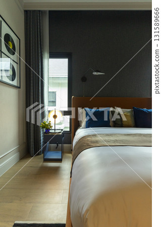 Interior view of modern bedroom with blue and yellow pillow on bed. Interior view of modern bedroom with blue and yellow pillow on bed. 131589666
