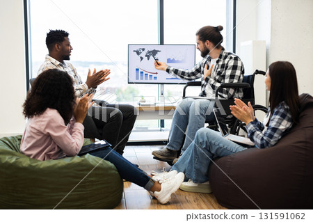 Multiethnic group of colleagues applauding male speaker presenting on global business statistics. Young professionals engaging in discussion about analytics and teamwork in office environment Multiethnic group of colleagues applauding male speaker presenting on global business statistics. Young professionals engaging in discussion about analytics and teamwork in office environment 131591062