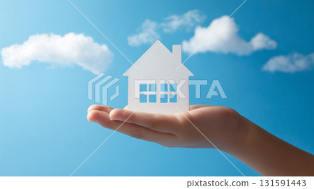 一個男孩手裡拿著一個房子的紙模型 一個男孩手裡拿著一個房子的紙模型 131591443