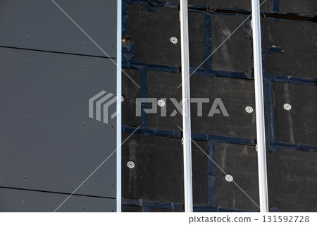 Modern building wall under construction, showing insulation layers, fastening elements, metal 131592728