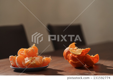 Peeled tangerines on a walnut wood table 131592774