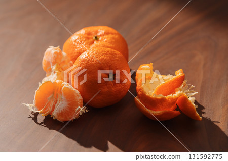 Peeled tangerines on a walnut wood table Peeled tangerines on a walnut wood table 131592775
