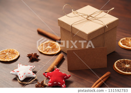 Christmas gift box from eco friendly paper wrapped with natural twine on wood table with natural decorations and stop card Christmas gift box from eco friendly paper wrapped with natural twine on wood table with natural decorations and stop card 131592783