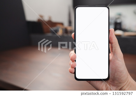 Man hand hold phone with white screen over black walnut table background Man hand hold phone with white screen over black walnut table background 131592797
