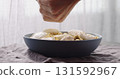 add spices to mozzarella with fusilli pasta with pesto in blue bowl 131592967