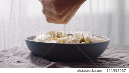 add spices to mozzarella with fusilli pasta with pesto in blue bowl 131592967