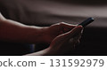 Closeup young man in black t-shirt typing messages on smartphone working from home side view 131592979