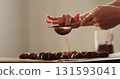 young woman sprinkle cocoa powder on chocolate truffles 131593041
