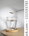 A spoon of Himalayan salt is being added to a glass of drinking water. 131593785
