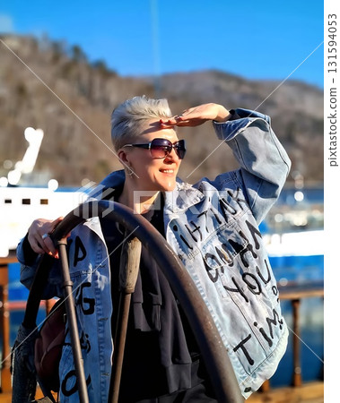 Happy Woman Steering Boat on Bright Sunny Day Happy Woman Steering Boat on Bright Sunny Day 131594053