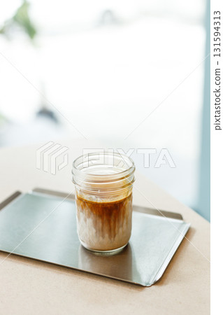 Cup of chilled milk dirty coffee on table by the window. Selective focus. 131594313