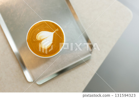 Cup of hot milk latte coffee with heart shape latte art on table. 131594323