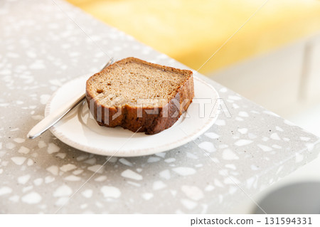 Moist Peanut butter Banana bread sliced with sauce on ceramic plate by the window. 131594331