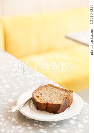 Moist Peanut butter Banana bread sliced with sauce on ceramic plate by the window. 131594333