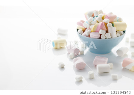 Colorful marshmallows in a bowl on white table background. Colorful marshmallows in a bowl on white table background. 131594543