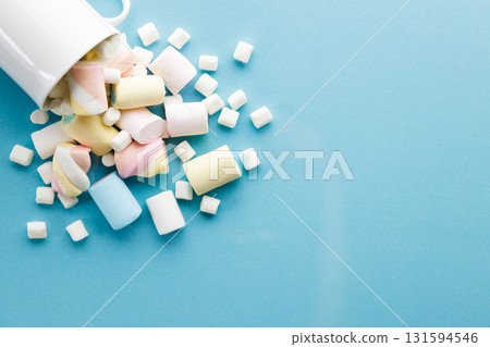 Colorful marshmallows on a vibrant blue background. Colorful marshmallows on a vibrant blue background. 131594546