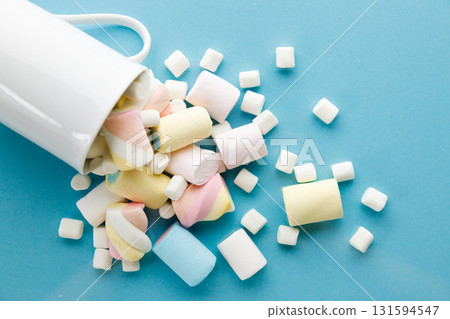 Colorful marshmallows on a vibrant blue background. Colorful marshmallows on a vibrant blue background. 131594547