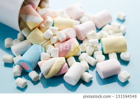 Colorful marshmallows on a vibrant blue background. Colorful marshmallows on a vibrant blue background. 131594548