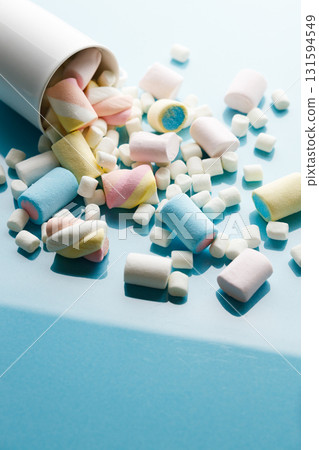 Colorful marshmallows on a vibrant blue background. Colorful marshmallows on a vibrant blue background. 131594549