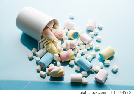 Colorful marshmallows on a vibrant blue background. Colorful marshmallows on a vibrant blue background. 131594550