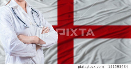 Doctor with crossed arms on England flag. England health and care concept. Female doctor on England flag Doctor with crossed arms on England flag. England health and care concept. Female doctor on England flag 131595484