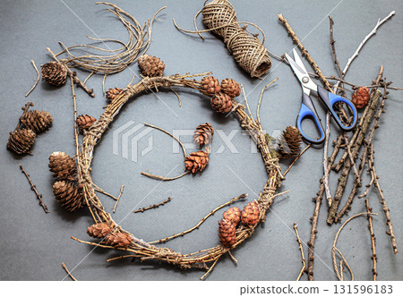 The process of making a natural Christmas wreath from natural fir branches and cones, without the use of plastic The process of making a natural Christmas wreath from natural fir branches and cones, without the use of plastic 131596183