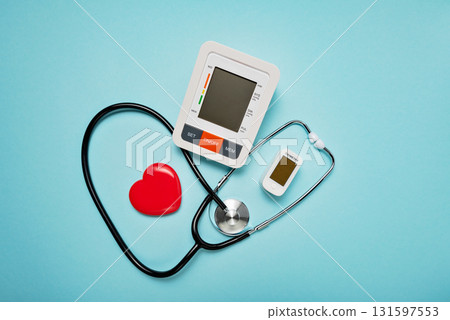 stethoscope, heart model, pills, and digital devices on Pale Blue Background symbolizing love and care in the medical field. stethoscope, heart model, pills, and digital devices on Pale Blue Background symbolizing love and care in the medical field. 131597553