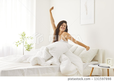 Happy Woman Stretching In Bed After Waking Up To A New Day At Home 131597898